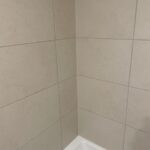 Shower corner picture of newly re-grouted and new caulking.